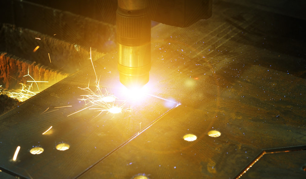 The process of cutting metal using plasma cutting.